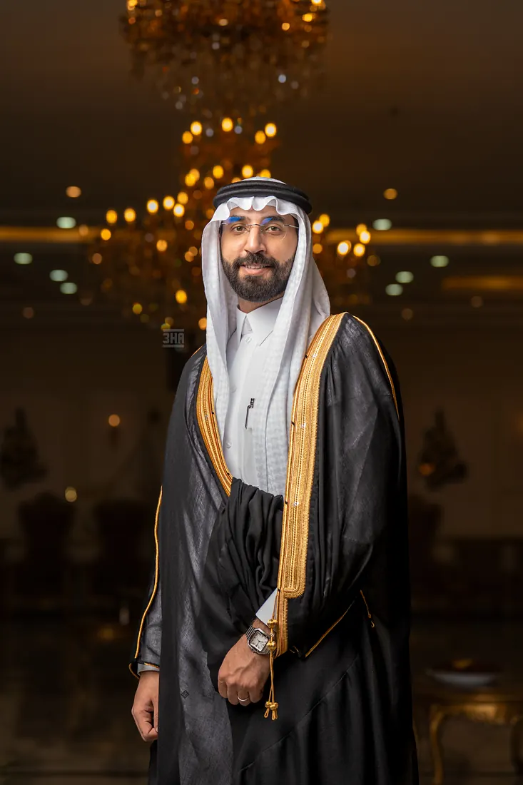 العريس يلتفت جانبًا بابتسامة تحت الثريا