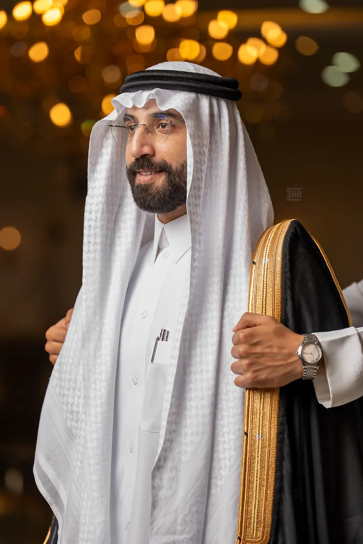 بورتريه قريب للعريس يمسك حاشية بشته الذهبية